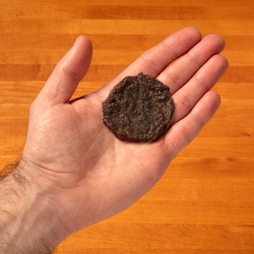 hand holding a single beef burger
