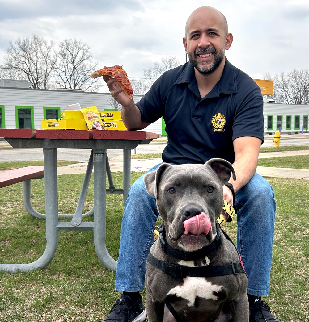 David eating pizza with a dog